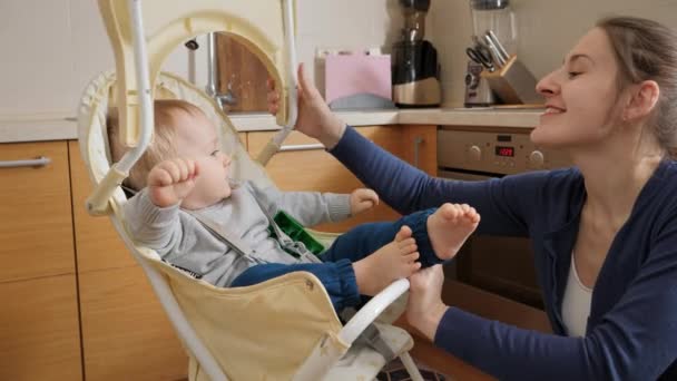 Jovem Mãe Sentando Seu Filho Bebê Cadeira Alta Desdobrando Mesa — Vídeo de Stock