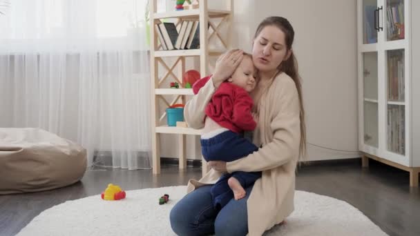 Hermosa Madre Joven Abrazando Calmando Niño Molesto Suelo Casa Desarrollo — Vídeo de stock