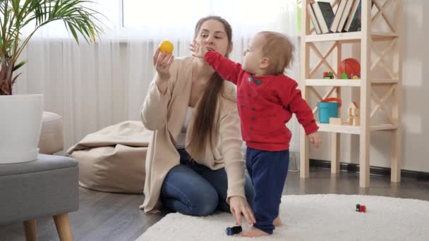 Bayi Laki Laki Kecil Mengambil Mainan Berwarna Warni Dari Ibunya — Stok Video