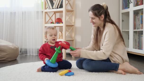Kleines Baby Mit Mutter Lernt Bunte Spielzeugpyramide Auf Dem Boden — Stockvideo