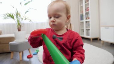 Renkli oyuncak kulesini kurduktan sonra gülümseyen sevimli bebek. Bebek gelişimi, çocuk oyunları, eğitim ve öğrenim