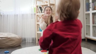 1 yaşındaki bir çocuk annesine doğru ilk adımını atıyor ve yerde sürünüyor. Bebek gelişimi, çocuk oyunları, eğitim ve öğrenim