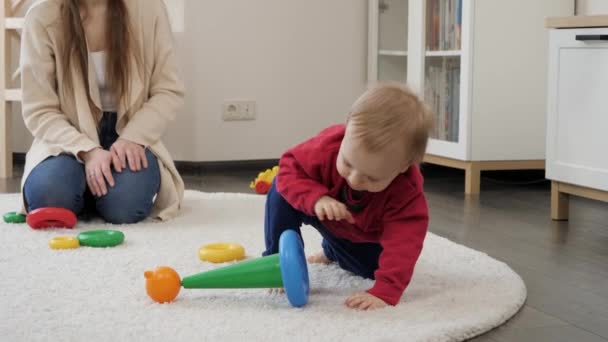 小男孩在客厅的地毯上学习走路和捡起玩具 幼儿发展 儿童游戏 教育和学习 — 图库视频影像