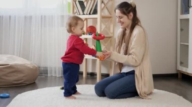 Annesiyle oynayan ve oyuncak kulesini monte eden 1 yaşında tatlı bir çocuk. Bebek gelişimi, çocuk oyunları, eğitim ve öğrenim