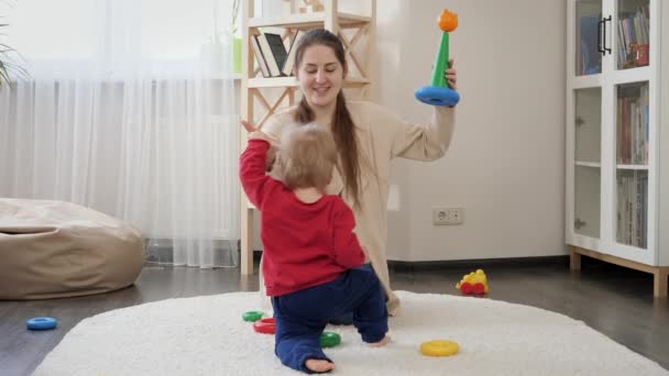 Fiatal Anya Megtanítja Kisfiát Sétálni Színes Játékokat Mutatva Neki Babafejlesztés — Stock videók