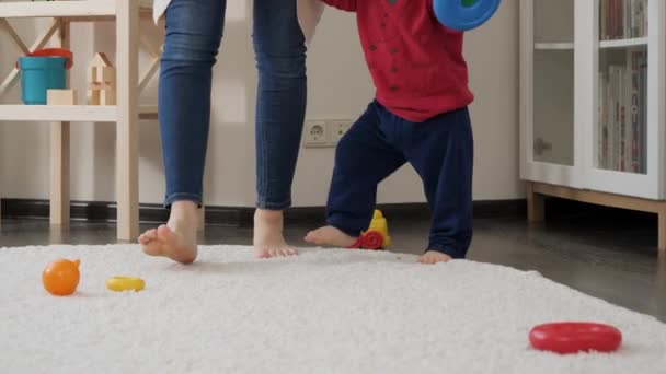 Zbliżenie Małego Dziecka Boso Młodą Matką Chodzącą Miękkim Dywanie Salonie — Wideo stockowe