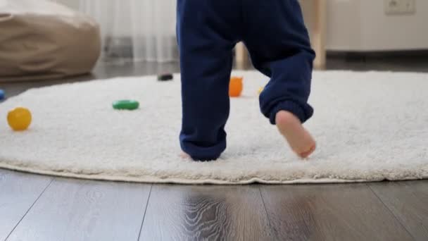 Zbliżenie Boso Chłopiec Robi Pierwsze Kroki Białym Dywanie Salonie Stópki — Wideo stockowe