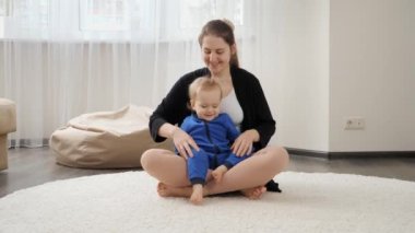 Küçük oğluna yoga öğretirken yoga yaparken gülümseyen mutlu bir anne. Aile sağlığı, aktif yaşam tarzı, ebeveynlik ve çocuk gelişimi