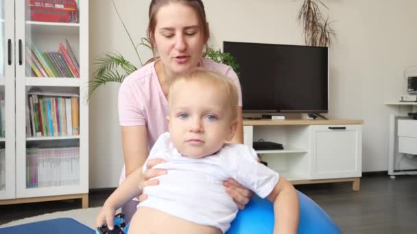 Kleine Baby Jongen Met Jonge Moeder Doet Fitness Fitbal Woonkamer — Stockvideo