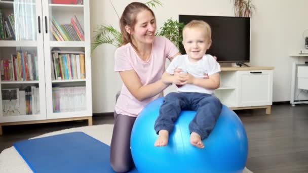 Boldog Mosolygó Kisfiú Ugrál Fitballon Anyával Otthon Egészségügy Sport Jóga — Stock videók