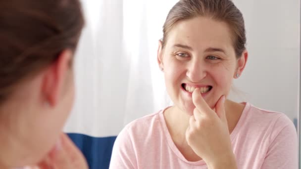 아름다운 미소짓는 여자가 자신의 치아를 확인하고 손가락으로 문지르는 건강의 — 비디오