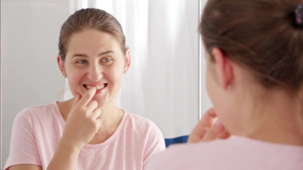 浴室で彼女の歯にプラークとキャリーを探して笑顔の若い女性の肖像画 歯の健康 自己点検口や口腔衛生の概念 — ストック動画