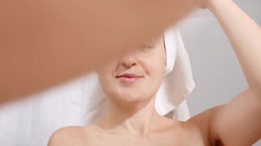 Uzun koltuk altı kılları olan güzel gülümseyen bir kadının portresi banyodaki yansımasına bakıyor. Güzel kadın kavramı, doğal güzellik, kadınlık ve vücut kılları.