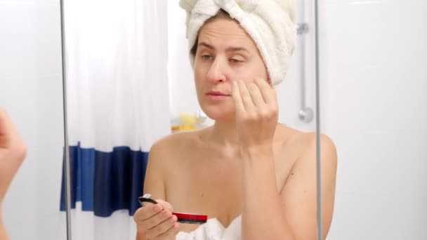 バスルームミラーにスポンジで顔の粉を適用する美しい若い女性の肖像画 美しい女性の概念 家庭での化粧 スキンケアと国内の美容業界 — ストック動画