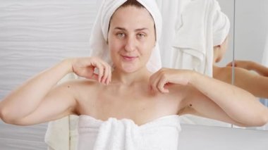 Uzun, siyah koltuk altı kılları olan güzel bir kadın banyo aynasında kollarını kaldırıyor. Hijyen, doğal güzellik, kadınlık ve vücut kıllarının uzaması kavramı