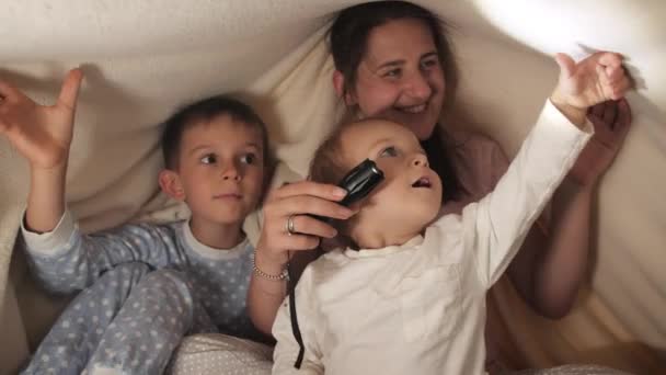 Dos Niños Madre Pijama Jugando Con Linterna Mientras Esconden Debajo — Vídeos de Stock