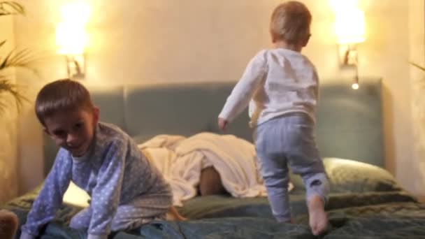两个穿着睡衣的可爱男孩玩的很开心 晚上还在床上爬行 有时间在一起的家庭 养育子女 快乐的童年和娱乐 — 图库视频影像