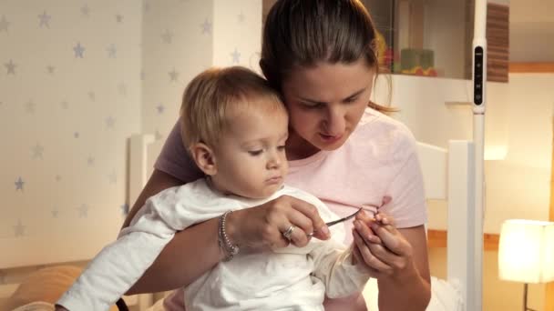 Retrato Uma Jovem Mãe Concentrada Cortar Unhas Bebé Pais Higiene — Vídeo de Stock