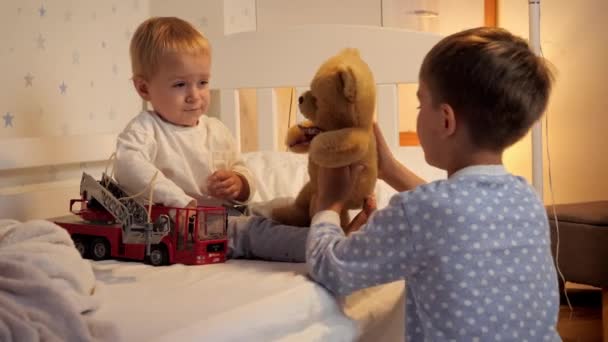 Двоє Хлопчиків Піжамі Граються Іграшками Ліжку Перед Сном Сім Проводить — стокове відео