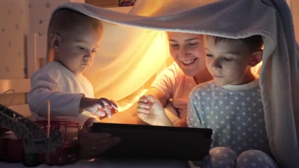 Два Улыбающихся Мальчика Пижаме Играют Видеоигры Планшетном Компьютере Мамой Ночам — стоковое видео