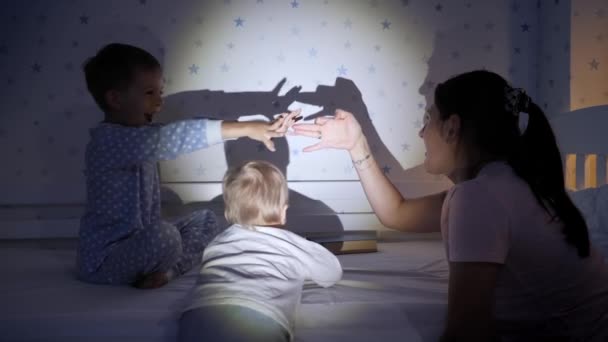 Fröhliche Kinder Mit Ihrer Mutter Die Nachts Mit Den Schatten — Stockvideo