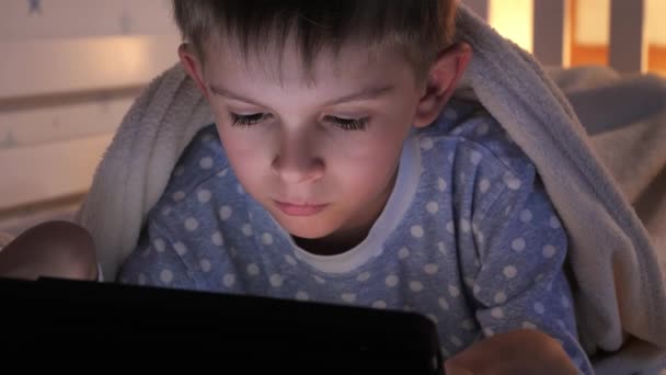 Μικρό Αγόρι Ξαπλωμένο Στο Κρεβάτι Tablet Υπολογιστή Και Βλέποντας Βίντεο — Αρχείο Βίντεο