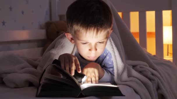 Мальчик Лежит Постели Одеялом Читает Книгу Факелом Обучение Детей Развитие — стоковое видео