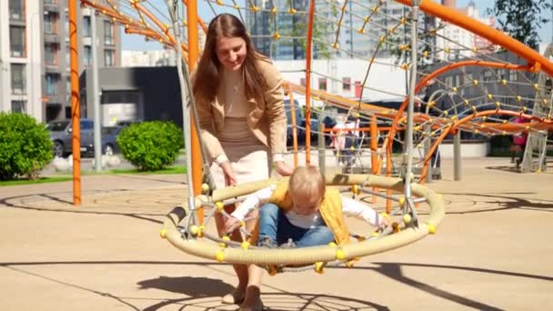 Feliz Mãe Sorridente Balançando Seu Filho Bebê Balanço Playground Crianças — Vídeo de Stock