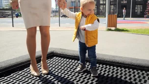 Zpomalený Pohyb Malého Chlapečka Držícího Matky Ruku Skákajícího Trampolíně Venku — Stock video