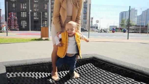 Rallentatore Giovane Madre Che Tiene Suo Bambino Saltando Sul Trampolino — Video Stock