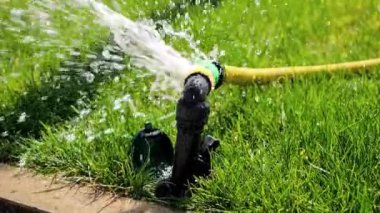 Sızdıran hortum borusundan akan su akımının yavaş hareketi. Su atıkları, bahçe malzemeleri, bahçe işleri.