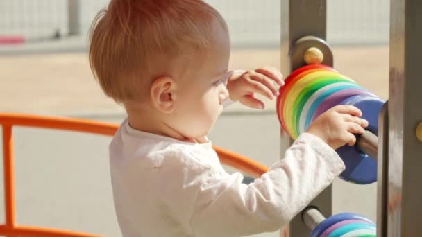 遊び場でそろばんにカラフルな円を回転させる小さな男の子の肖像画 子供の発達子供の教育赤ちゃんの学習 — ストック動画