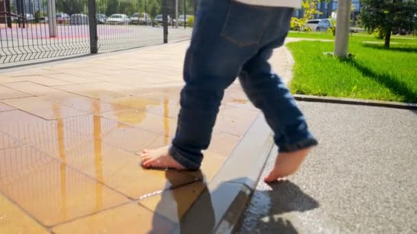 Närbild Barfota Baby Pojke Promenader Vattnet Pöl Gatan Solig Sommardag — Stockvideo