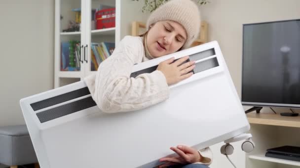 Ung Kvinna Omfamnar Elektrisk Värmare Sin Lägenhet Med Uppvärmningsproblem Begreppet — Stockvideo