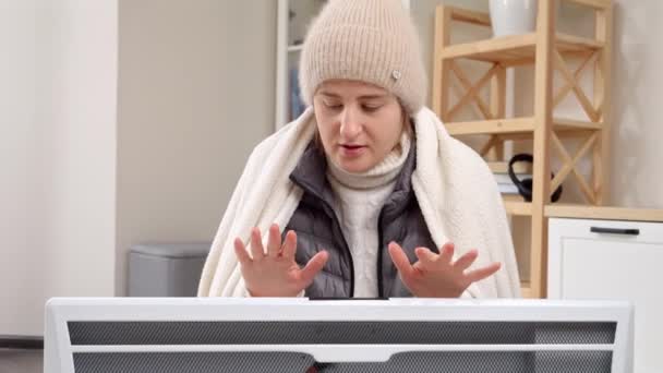 Μια Παγωμένη Γυναίκα Στο Σπίτι Της Ζεσταίνεται Στο Ηλεκτρικό Καλοριφέρ — Αρχείο Βίντεο