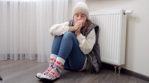 一个心烦意乱的女人想在冷冰冰的公寓里取暖而不取暖 能源危机概念 高额费用 供热系统中断 节约和节省每月公用事业付款 — 图库视频影像