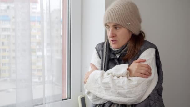 Mujer Joven Con Sombrero Suéter Congelándose Casa Mirando Por Ventana — Vídeos de Stock