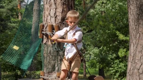 户外夏令营过桥时 集中男孩手持安全绳的肖像 活跃的童年 健康的生活方式 户外玩耍的孩子 大自然中的孩子 — 图库视频影像