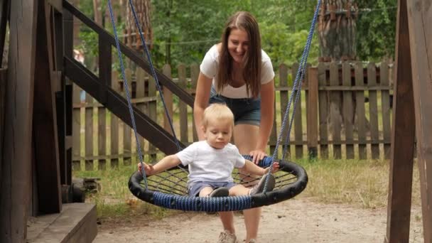 Jovem Mãe Empurrando Seu Filho Bebê Balançando Ninho Corda Balançar — Vídeo de Stock