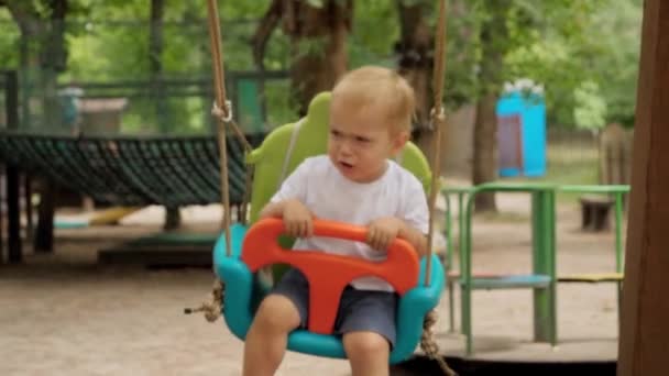 Porträtt Liten Olycklig Pojke Som Svänger Färgglad Gunga Parken Barn — Stockvideo