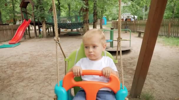 Primer Plano Del Niño Lindo Sentado Balanceándose Columpio Colorido Parque — Vídeo de stock