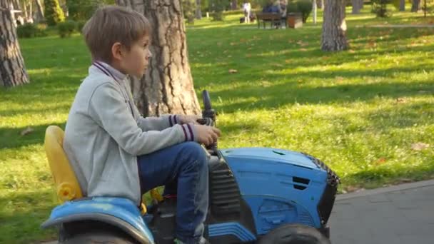 公园里骑着玩具拖拉机的快乐男孩 孩子们在公园里玩耍 — 图库视频影像