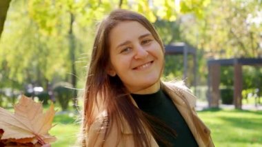 Sonbahar parkında bir buket sarı ağaç yaprağıyla dans eden mutlu kadın. Doğada güzellik, şehirde düşüş, mutlu kadınlar..