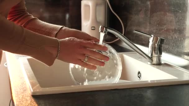 在厨房洗碗槽里洗盘子的年轻女人的衣服 家庭主妇工作 家务活 做家务活 — 图库视频影像