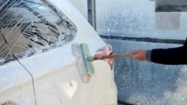 Kirli arabayı sabun köpüğü ve fırçayla yıkamaya yakın. Otomobil bakımı, ulaşım temizliği, kirli araba.