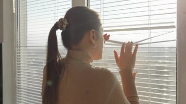 Genç bir kadın pencere perdelerinden baktıktan sonra korkmuş ve dehşete düşmüştü. Suç tanığı, pencereden gözetliyor, sokağı gözetliyor.