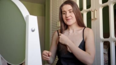 Gülümseyen esmer kadın saçını saç fırçasıyla tarıyor. Saç bakımı, kadın zarafeti ve güzelliği.