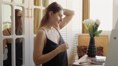 Uzun siyah saçlarına saç tokası takan zarif, güler yüzlü bir kadın. Saç bakımı, kadın sağlığı ve güzelliği.