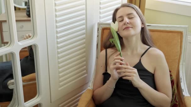 Mooie Glimlachende Vrouw Met Witte Tulp Ontspannen Een Fauteuil Slaapkamer — Stockvideo