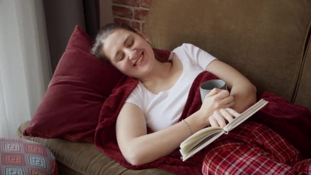 Schöne Lächelnde Frau Liest Lustiges Buch Während Sie Hause Auf — Stockvideo